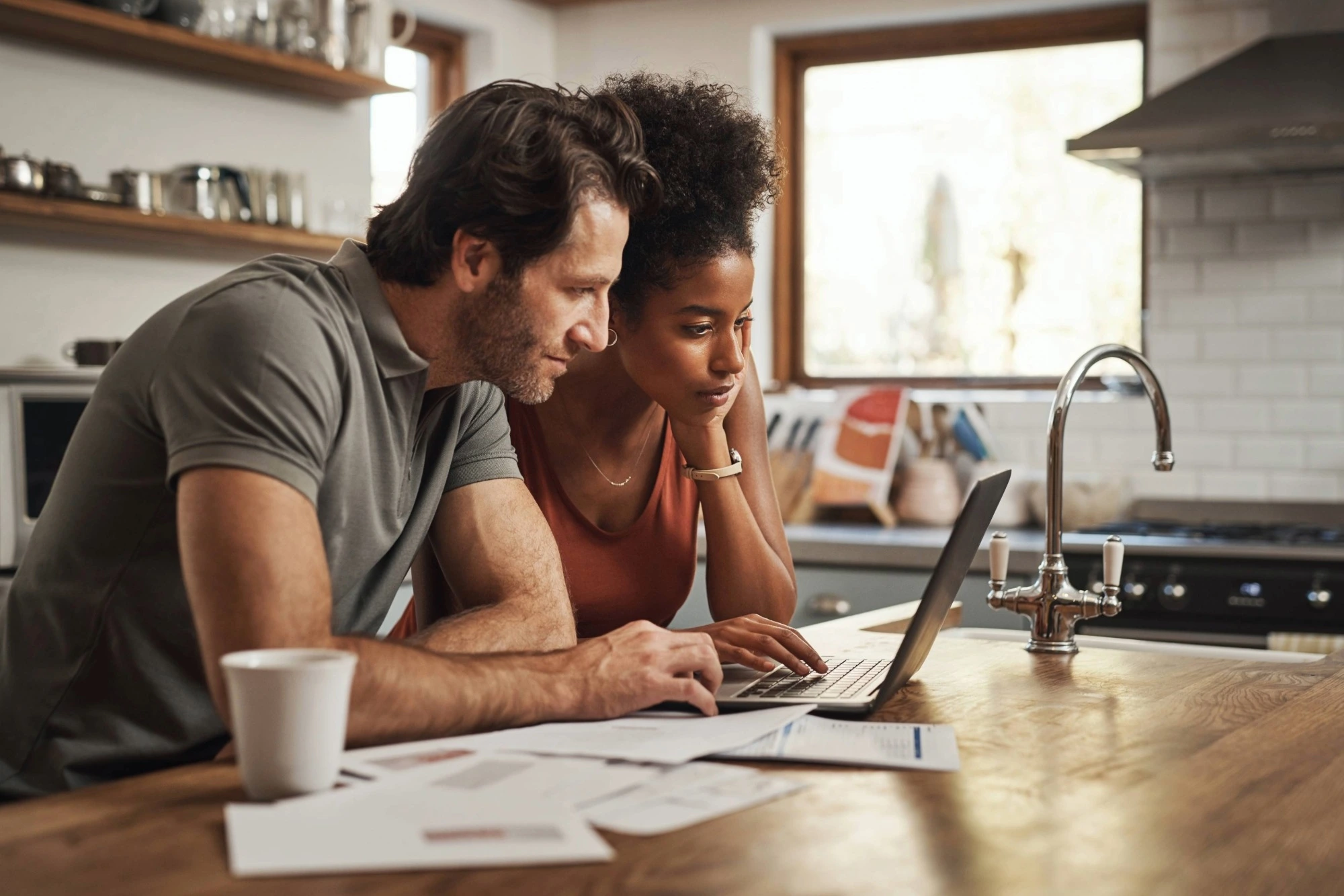 Homeowners reviewing HVAC financing options on a laptop at their kitchen table 